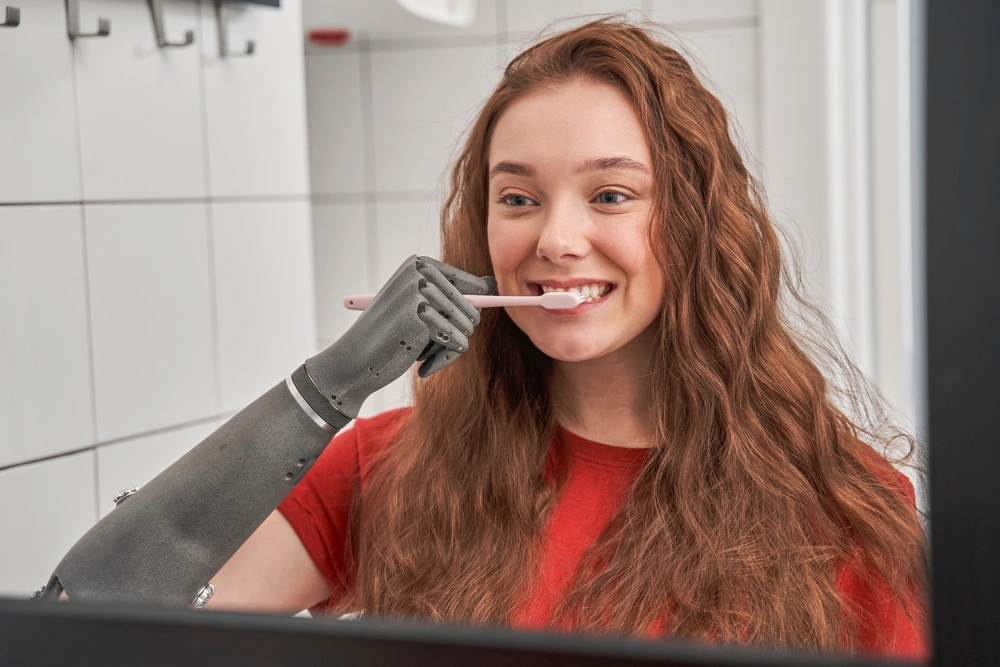 woman with prosthetic arm brushing her teeth