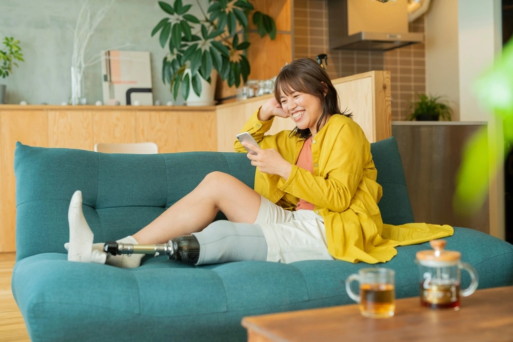 person with prosthetic leg sitting on a sofa